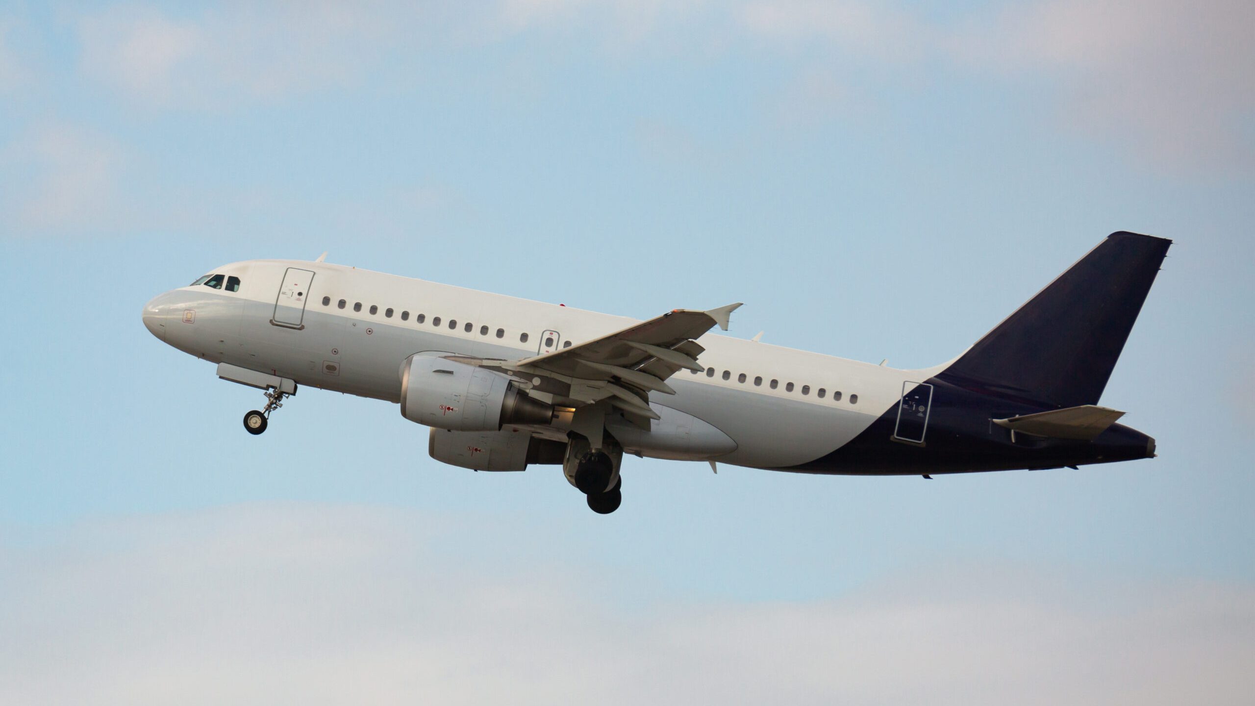 View of passenger airplane flying up in cloudy sky